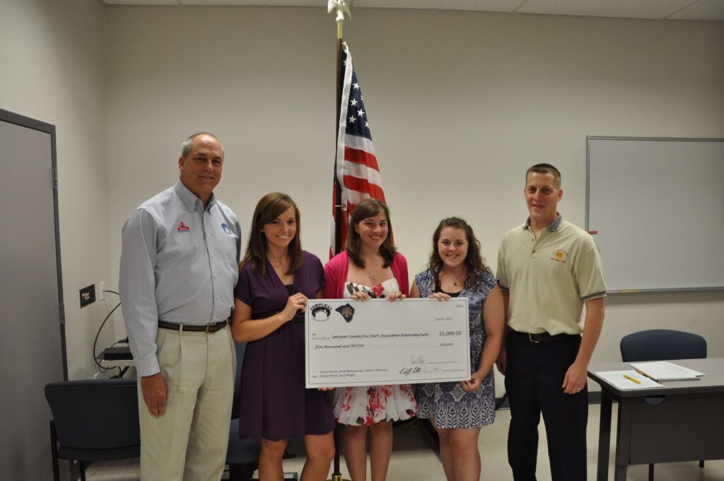 group of people holding a large check