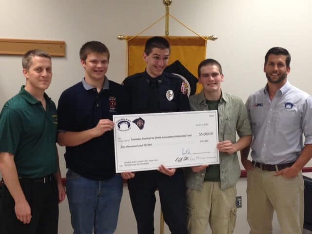 a group of men holding a large check