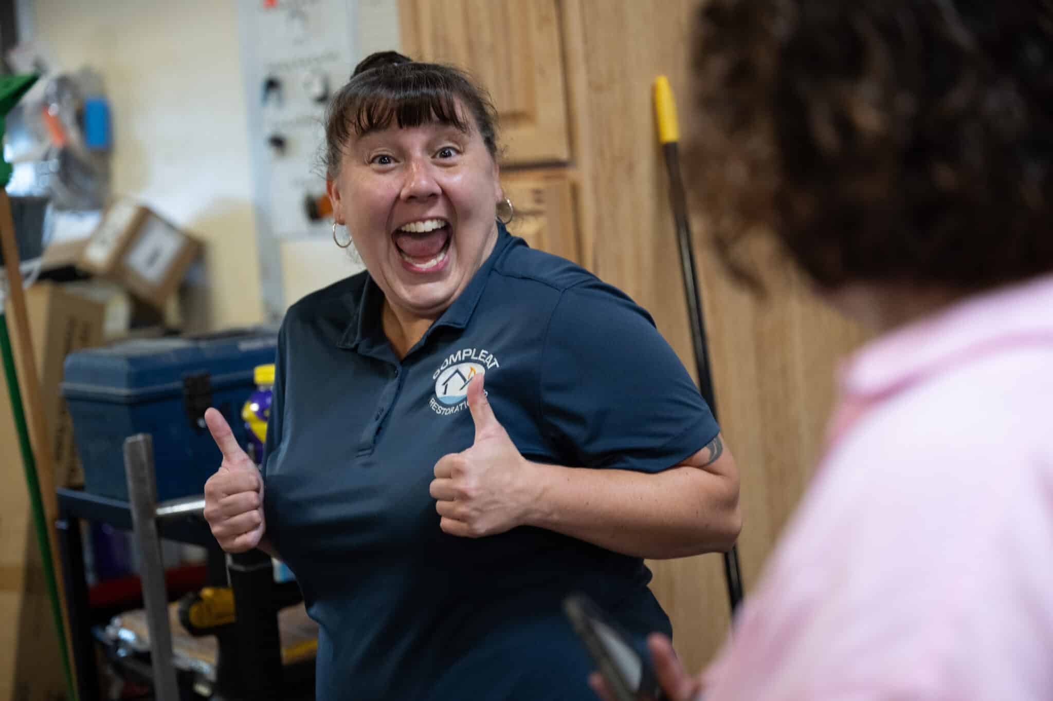 water restoration worker smiling with two thumbs up
