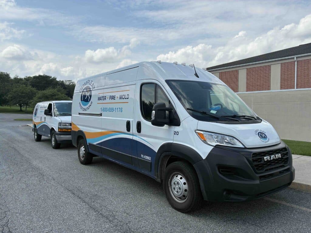 Compleat Restoration vans at water restoration job in Harrisburg PA
