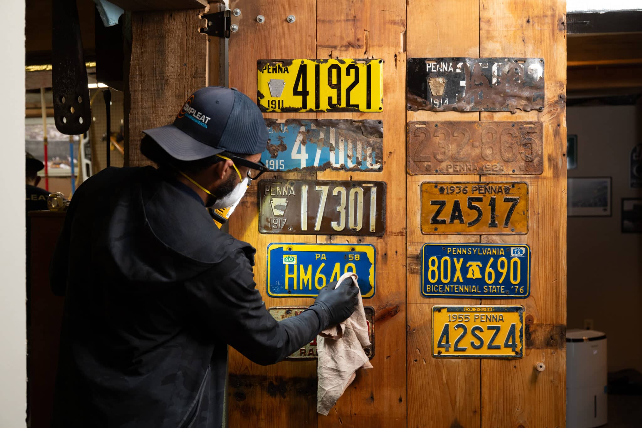 Worker cleaning vintage license plates