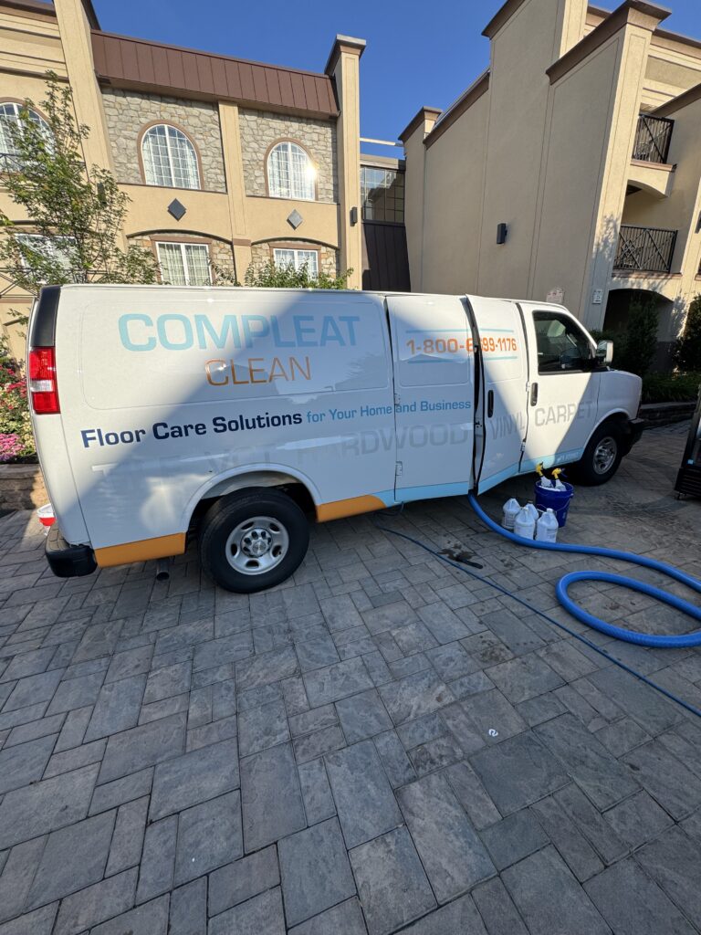 Compleat Clean service van in front of a commercial building